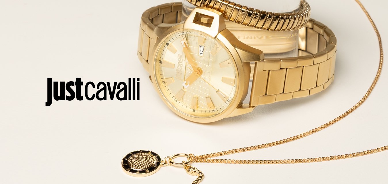 Dvě zlaté náramkové hodinky naskládané na průhledném stojanu a jemný zlatý náhrdelník s kruhovým černým a zlatým přívěskem na bílém povrchu.