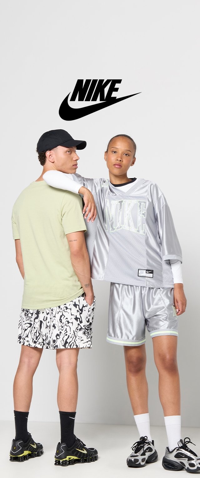 Ropa de Nike que incluye una camiseta verde claro, pantalones cortos con un patrón en blanco y negro, una camiseta de malla plateada y pantalones cortos a juego con acentos en neón.