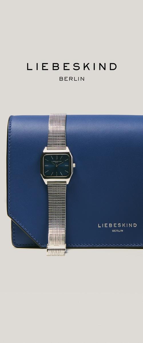 Blauwe leren Liebeskind Berlin clutch met een zilverkleurig mesh bandhorloge met een blauwe wijzerplaat erop, merknaam zichtbaar op beide.