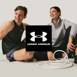 Dva dospělí v atletickém oblečení sedící na podlaze a usmívající se, mezi nimi stočené bílé cvičební lano, na jednobarevném pozadí.