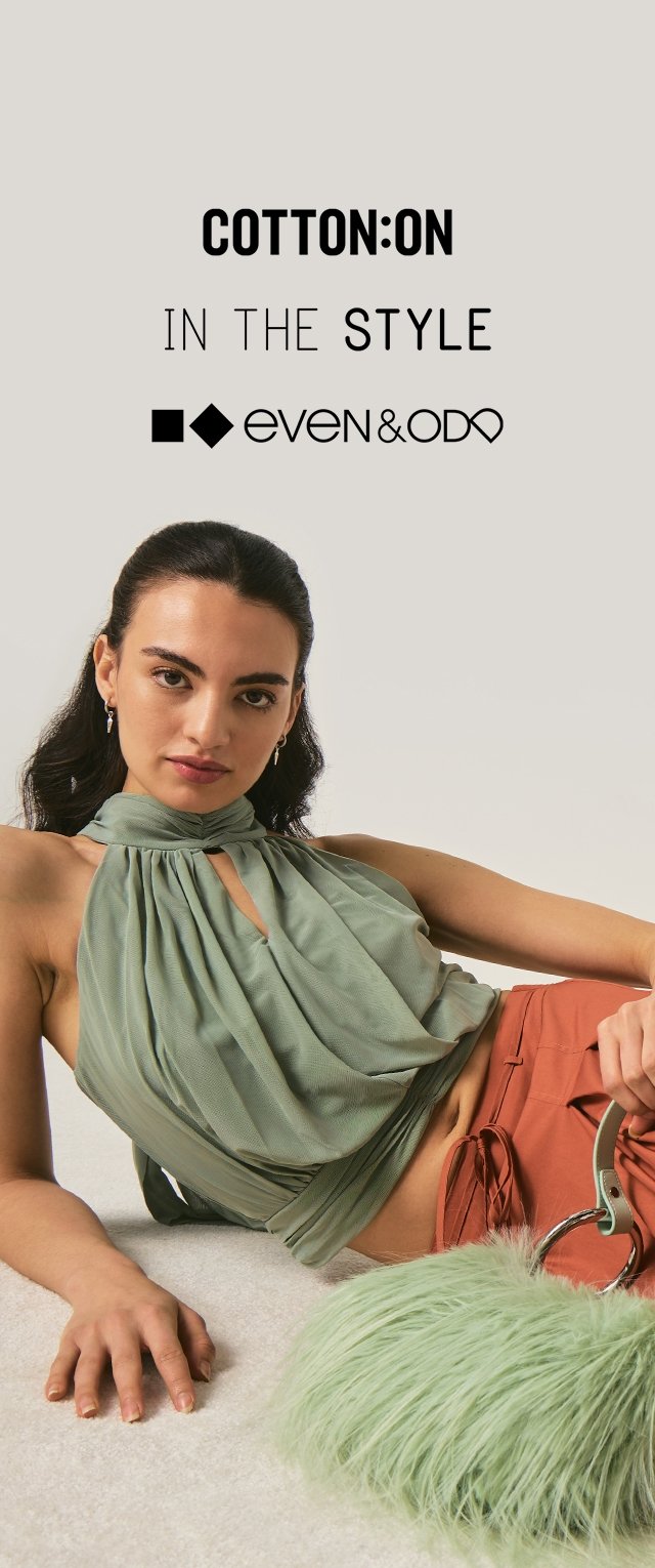 Mujer recostada con un top halter verde salvia y pantalones color óxido, sosteniendo un bolso peludo de color verde claro sobre un fondo beige con logotipos de marcas de moda arriba.