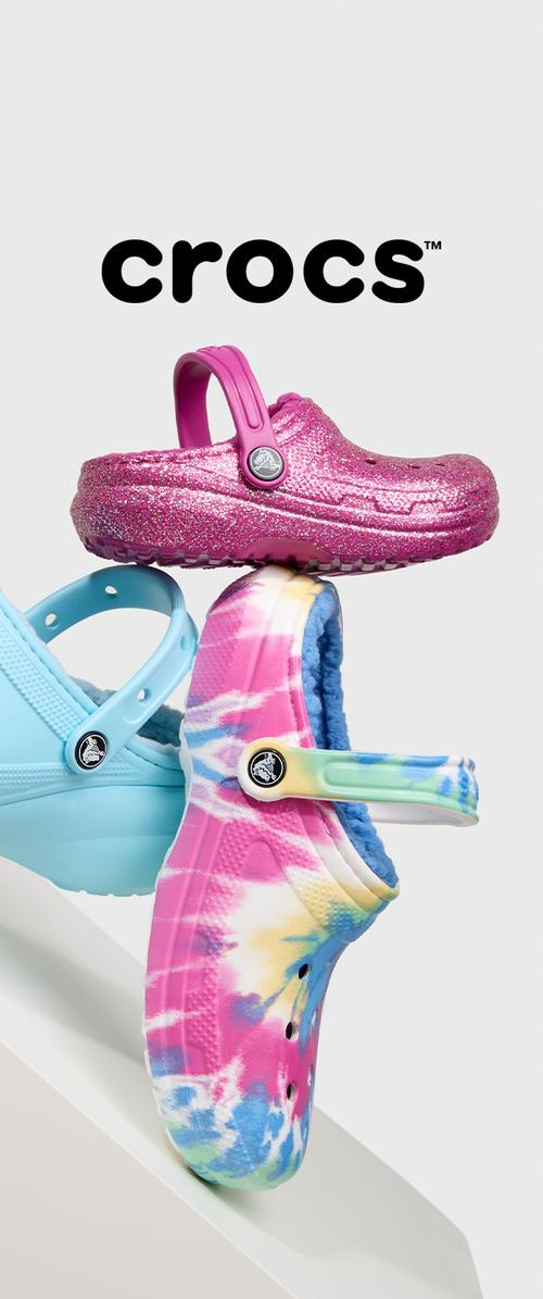 Rosa Glitzer-Crocs mit Riemen oben, blaue Crocs darunter mit glatter Textur und einem mehrfarbigen Batikdesign auf dem unteren Paar.