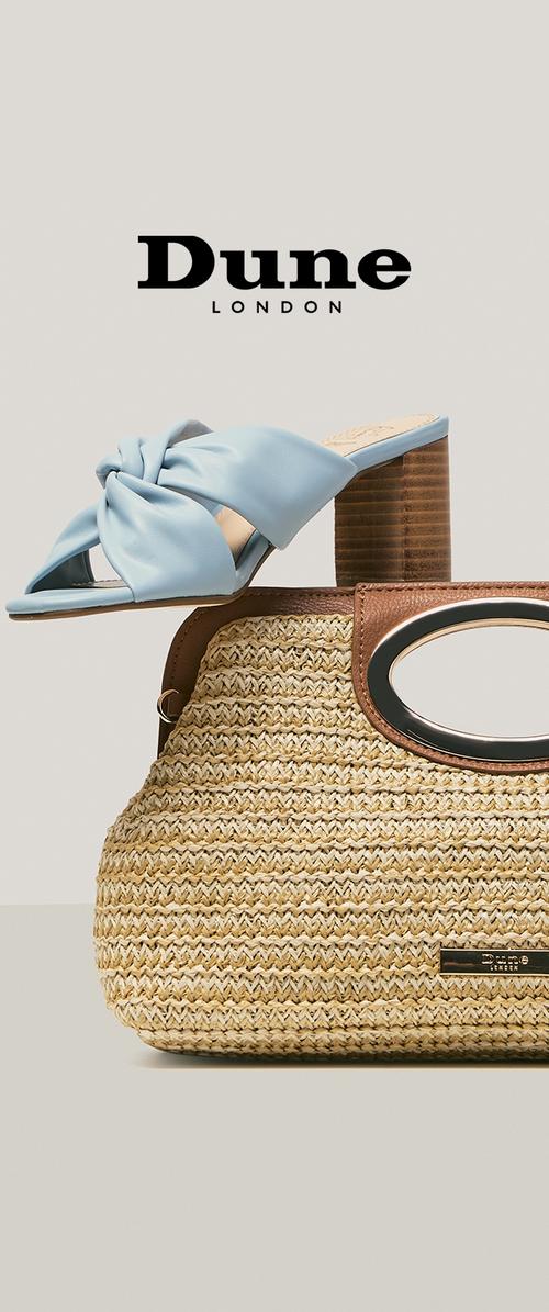 Light blue knot-detail slide sandal with block heel resting on woven straw handbag with oval handle and leather trim, Dune London logo above.