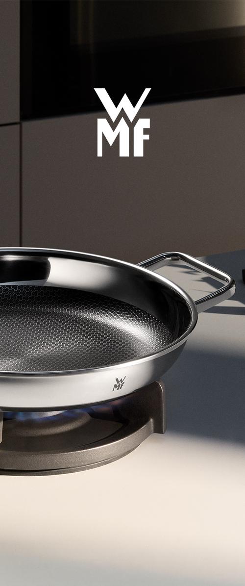 Sartén de acero inoxidable con superficie antiadherente en forma de panal sobre quemador de cocina de gas, con el logo de WMF en el lateral y al fondo.