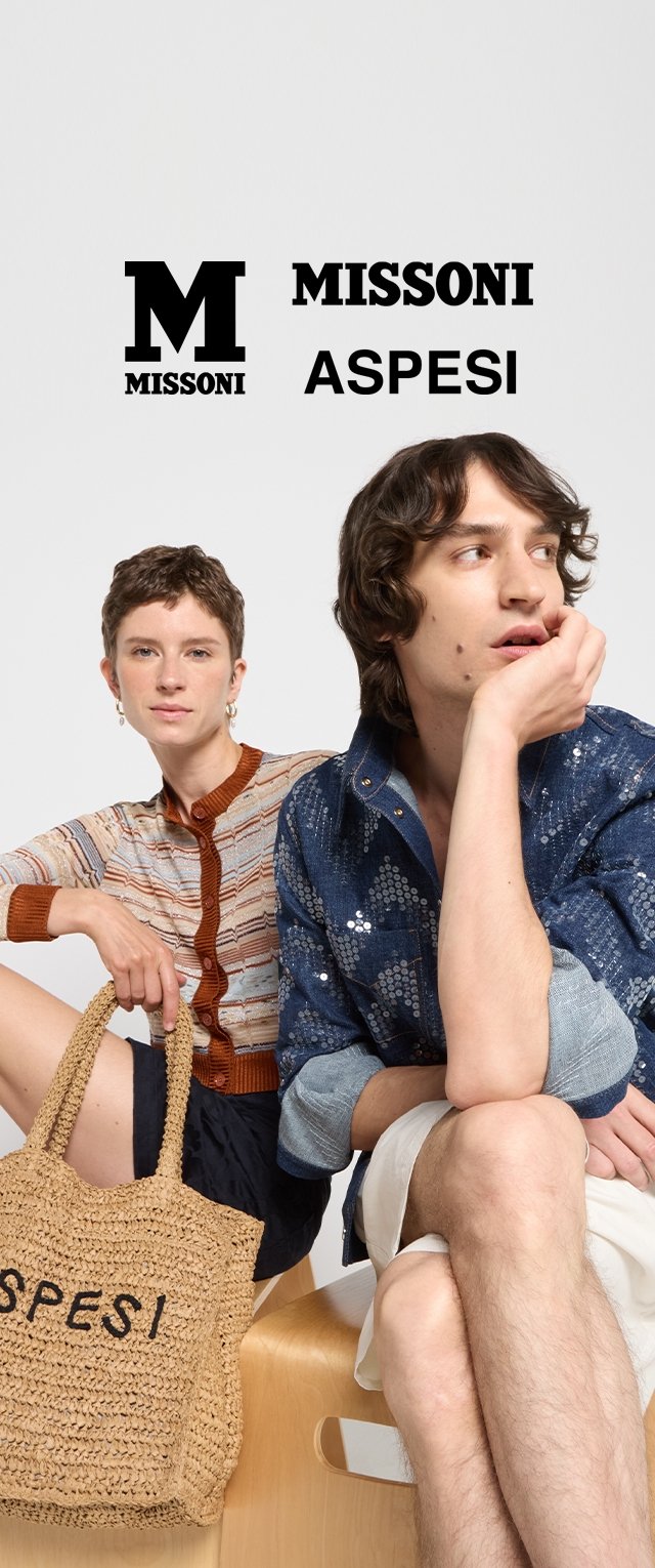 Dos modelos están sentadas sobre una superficie de madera. Una lleva un top de punto multicolor con un cuello marrón, y la otra una camisa azul con lentejuelas. Una bolsa de mimbre dice "ASPESI."