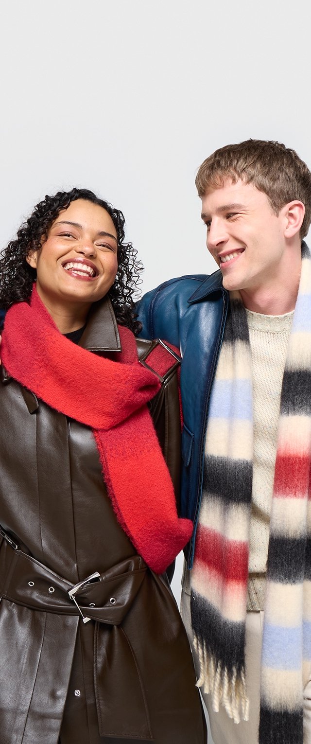 Manteau en cuir marron avec une ceinture, écharpe rouge en fourrure, veste en cuir bleue, pull crème texturé et écharpe rayée avec des motifs rouges, blancs et bleus.