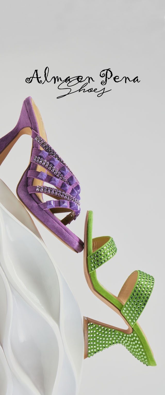 Fialová vysoká podpatková sandála s kamínky a zelená vysoká podpatková sandála s kamínky vyvážené na bílé sochařské ploše.