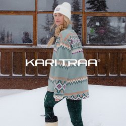 Svetr s geometrickými vzory v mátově zelené barvě, tmavozelené kalhoty a krémové boty, umístěné na zasněžené krajině.