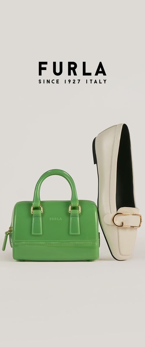 Žalias patentuotas odinis rankinės su dviem laikikliais, šalia baltų odinių loafers su auksine sagtimi. Abu gaminiai pažymėti "Furla".