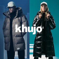 Dvé zateplených kabátů: jeden světle hnědý s vysokým límcem a zapínáním na knoflíky, a jeden lesklý černý s kapucí a zipovým zapínáním. Oba dlouhé a zateplené.