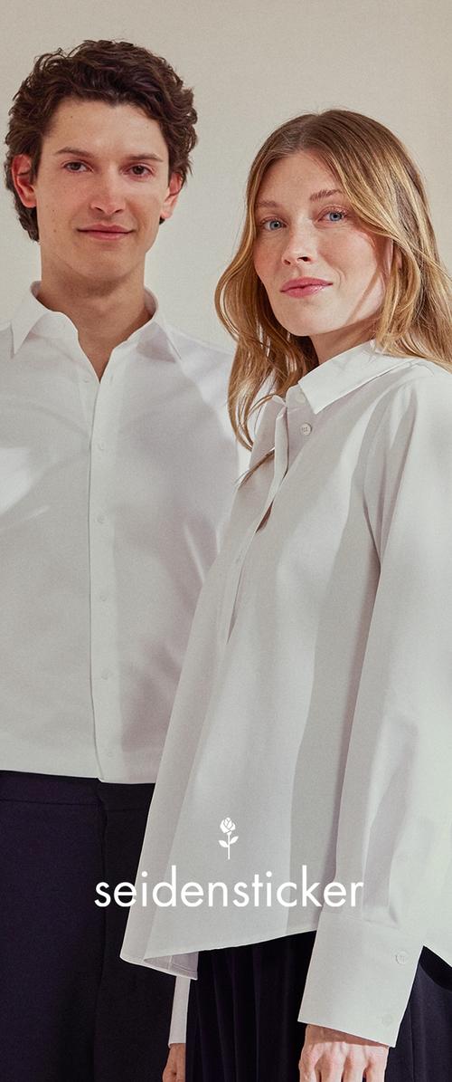 Camisas blancas de botones hechas de tela suave; una tiene un cuello clásico, la otra presenta un diseño drapeado. Logo de Seidensticker debajo.