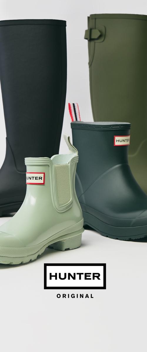 Cuatro pares de botas de goma en negro, verde oliva y verde claro, con un diseño de fácil puesta, suelas texturizadas y etiquetas de marca.