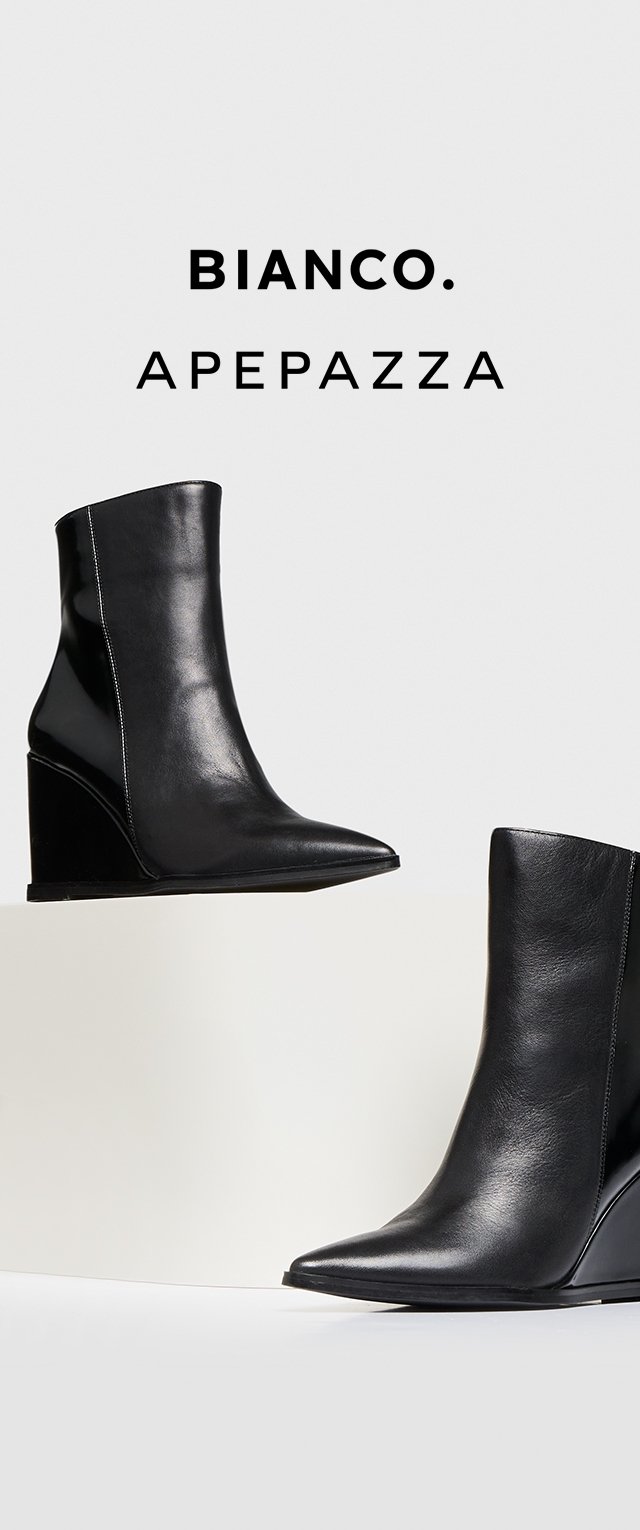 Black leather wedge ankle boots with a pointed toe, smooth texture, and seam detailing, positioned on a minimal white display.