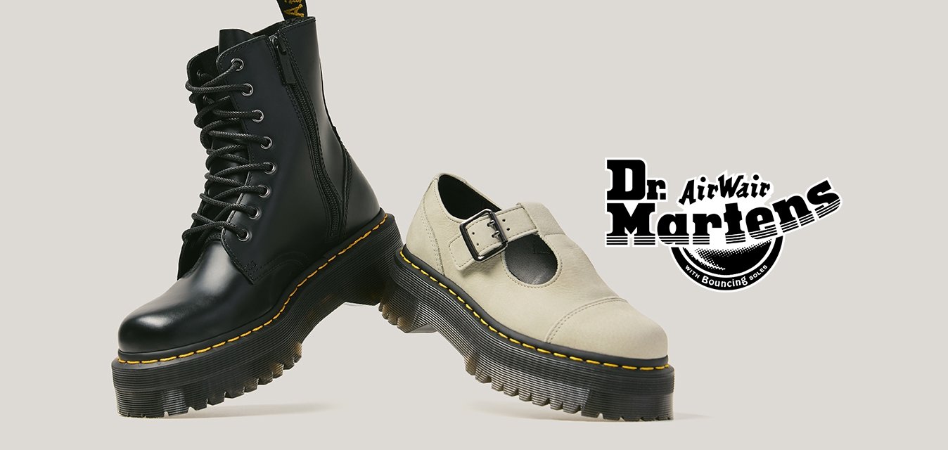 Černá kožená šněrovací bota a bílá bota typu Mary Jane, obě s tlustými podešvemi a žlutým prošitím, zobrazené vedle sebe.