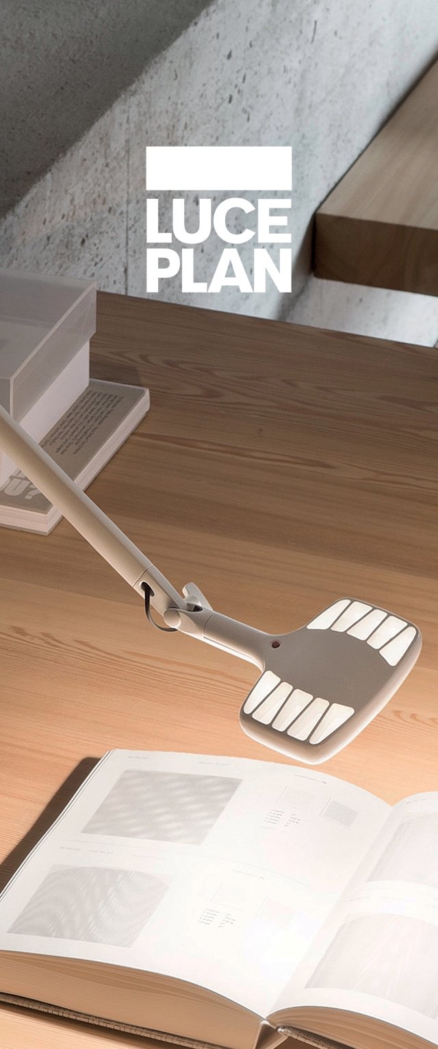 Lampada bianca regolabile con testa arrotondata e design a fessure, posizionata sopra un libro aperto su una superficie di legno. Aestetica semplice e moderna.