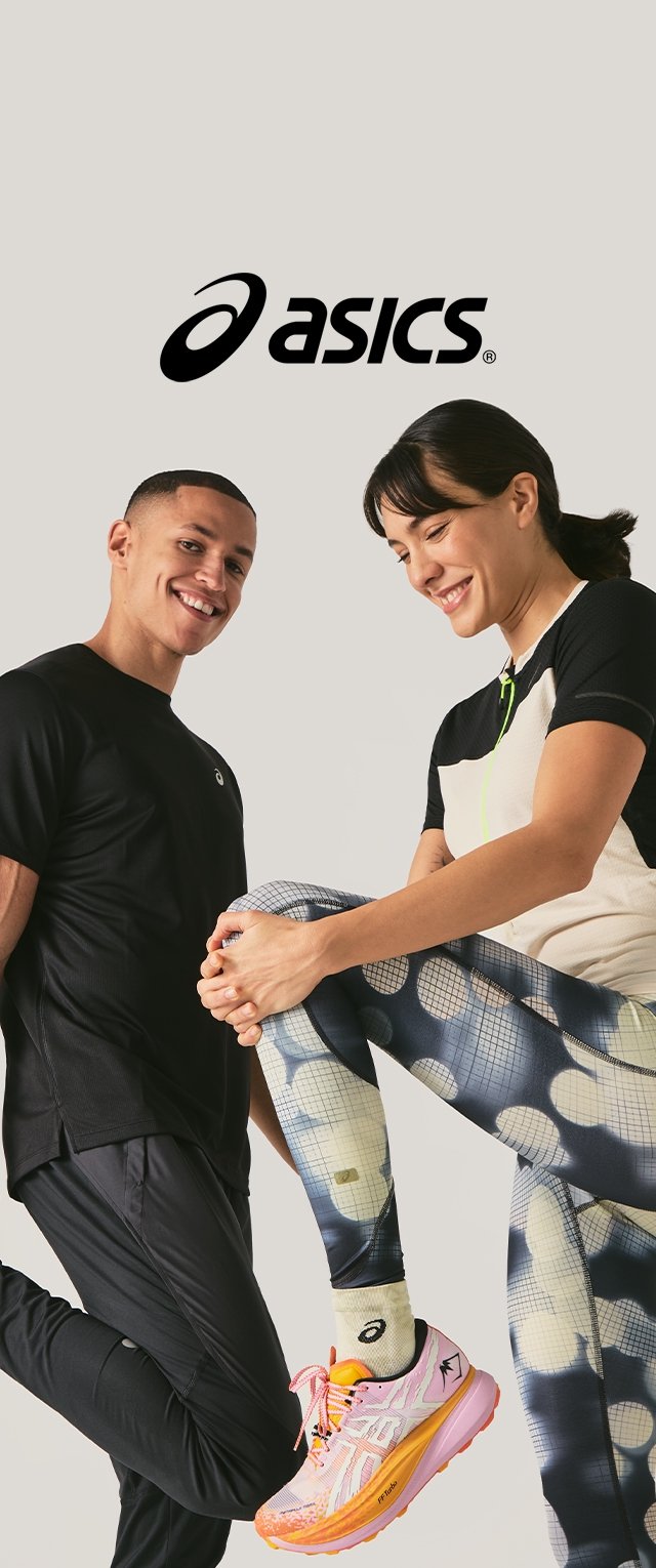 Camiseta deportiva negra, mallas estampadas en azul y blanco, zapatillas para correr ASICS rosas con detalles, sobre un fondo neutro.