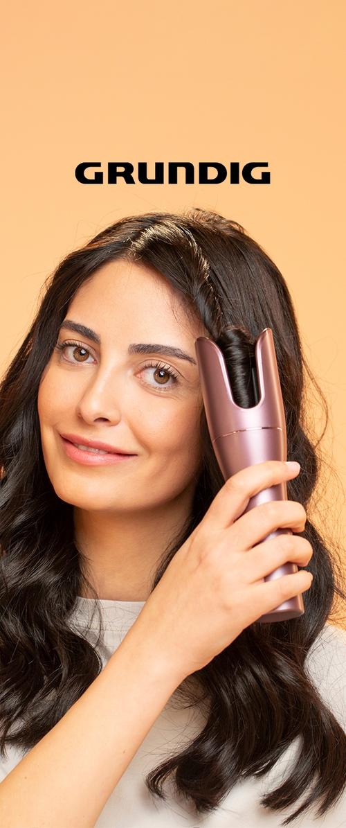 Fer à friser automatique de couleur rose, doté d'un design cylindrique avec une large ouverture pour boucler les cheveux, une texture lisse et une prise ergonomique.