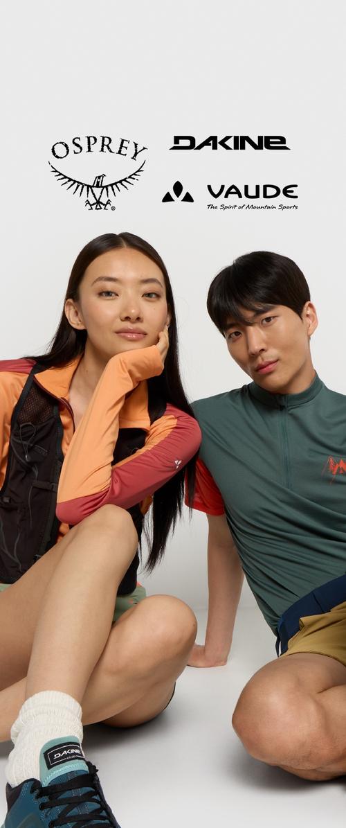 Twee modellen dragen buitenkleding: een oranje en bordeauxrood langmouwtop, en een groen kortmouwshirt. Logo's van Osprey, Dakine en Vaude zijn zichtbaar.