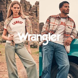 Muž se opírá o tyrkysový vintage náklaďák, zatímco žena stojí poblíž; oba mají na sobě neformální oblečení s kovbojskou tématikou v skalnaté pouštní krajině.