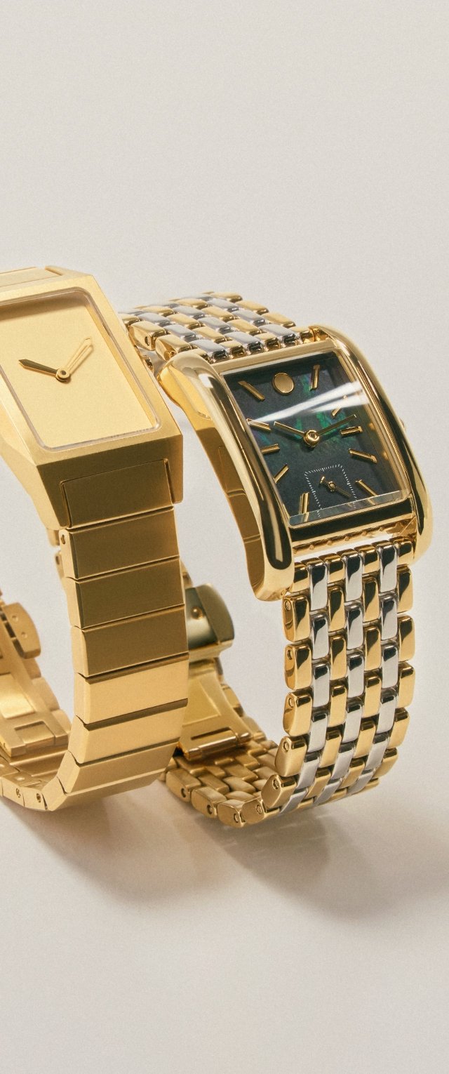 Twee gouden polshorloges met metalen banden, één met een eenvoudige gouden wijzerplaat en de andere met een donkere rechthoekige wijzerplaat en zilveren accenten.