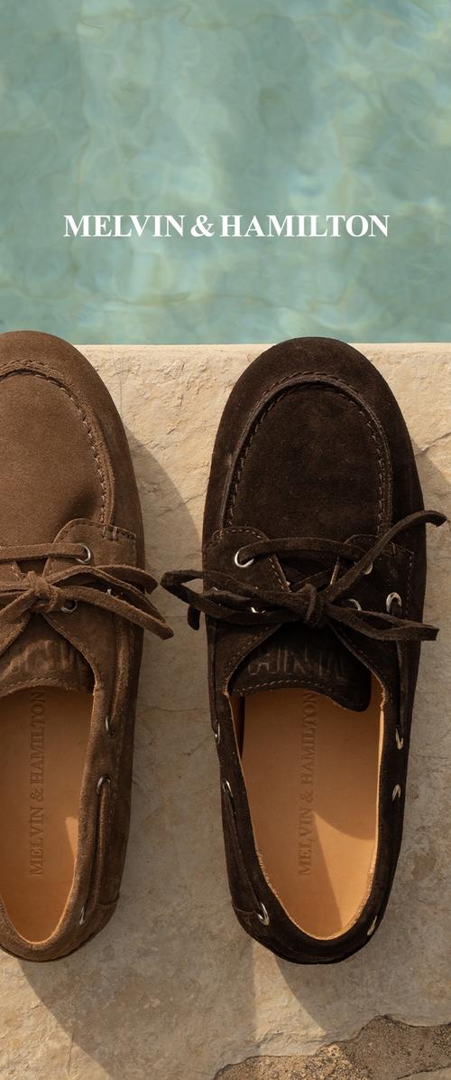 Braune Wildleder-Slipper mit zwei Ösen und Schnürsenkeln, ausgestattet mit einem glatten Innenfutter. Ein Schuh ist heller, der andere dunkler in der Farbe.