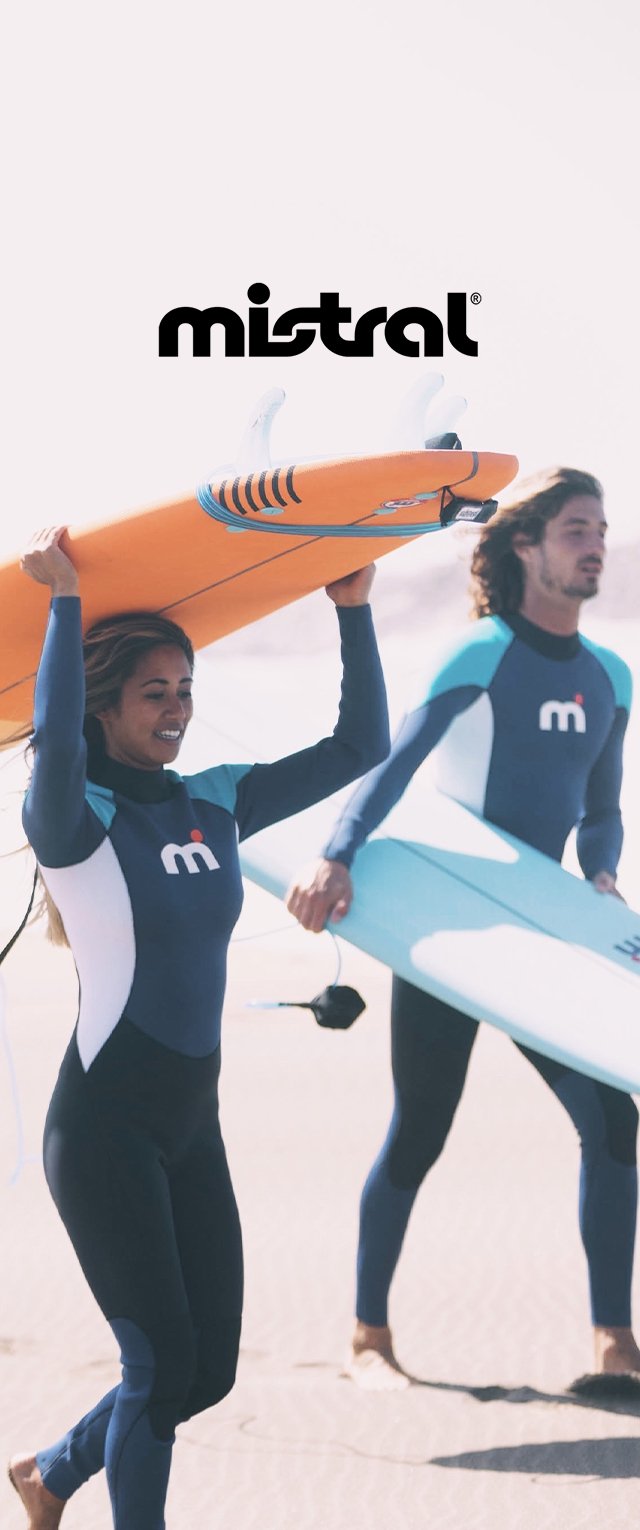 Twee personen dragen surfplanken: één oranje met blauwe accenten, de andere lichtblauw. Beide dragen strakke zwarte wetsuits met blauwe details.