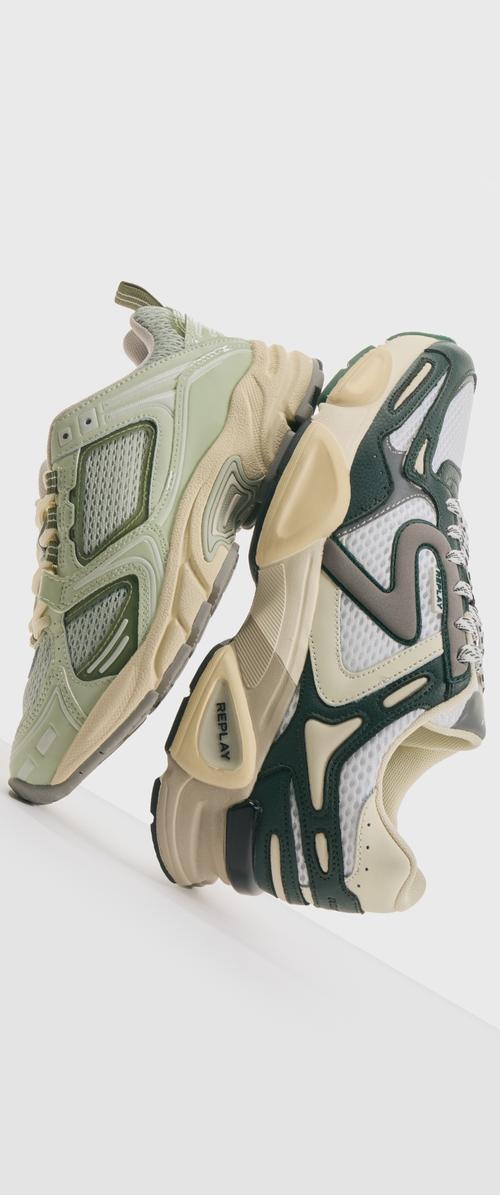 Zapatillas con una parte superior de malla color verde claro y beige, acentos en verde oscuro, suela gruesa color crema y un destacado logo de la marca en el lateral.