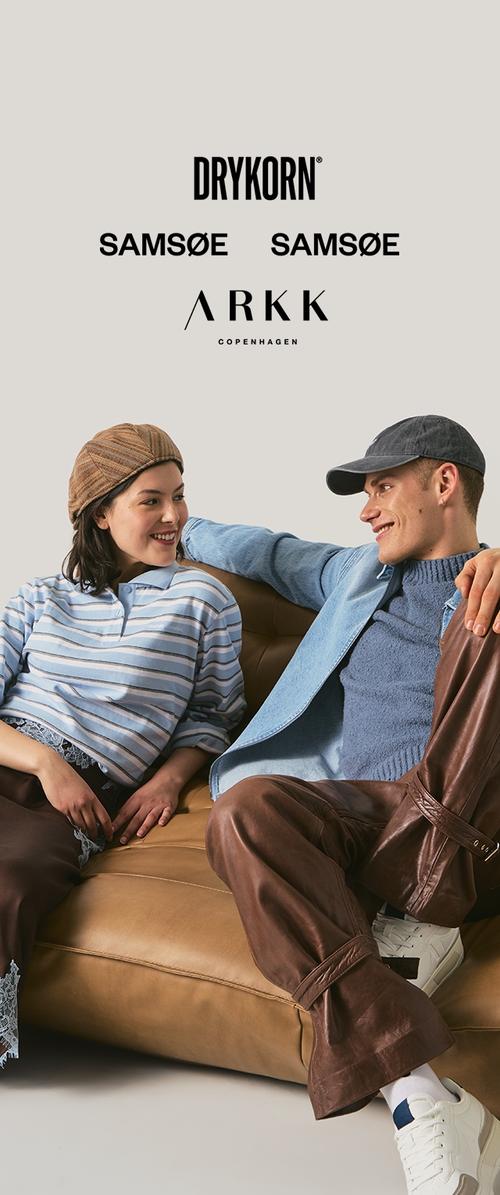 Junger Mann und Frau in lässiger Kleidung sitzen auf einem hellbraunen Sofa, lächeln und sehen sich an, Markenlogos über ihnen auf hellem Hintergrund.