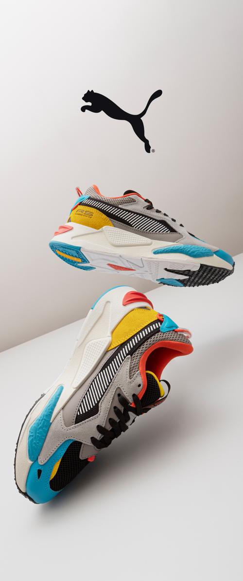 Multicolored athletic shoes featuring a blend of gray, black, orange, yellow, and blue accents. Textured material with a layered design.