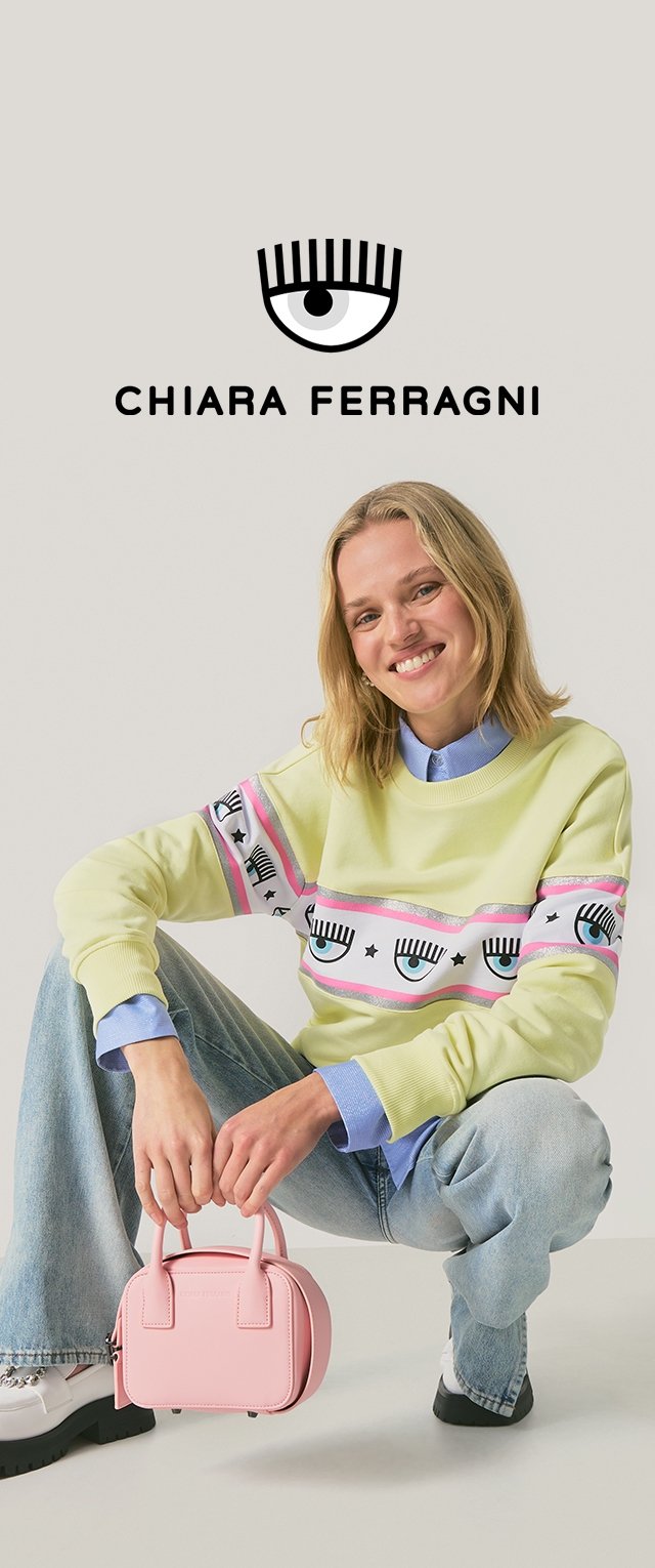 Jasnozielona bluza z nadrukiem oka i gwiazdy, noszona na niebieskiej koszuli z kołnierzykiem, w połączeniu z jasnoniebieskimi dżinsami i różową torebką.