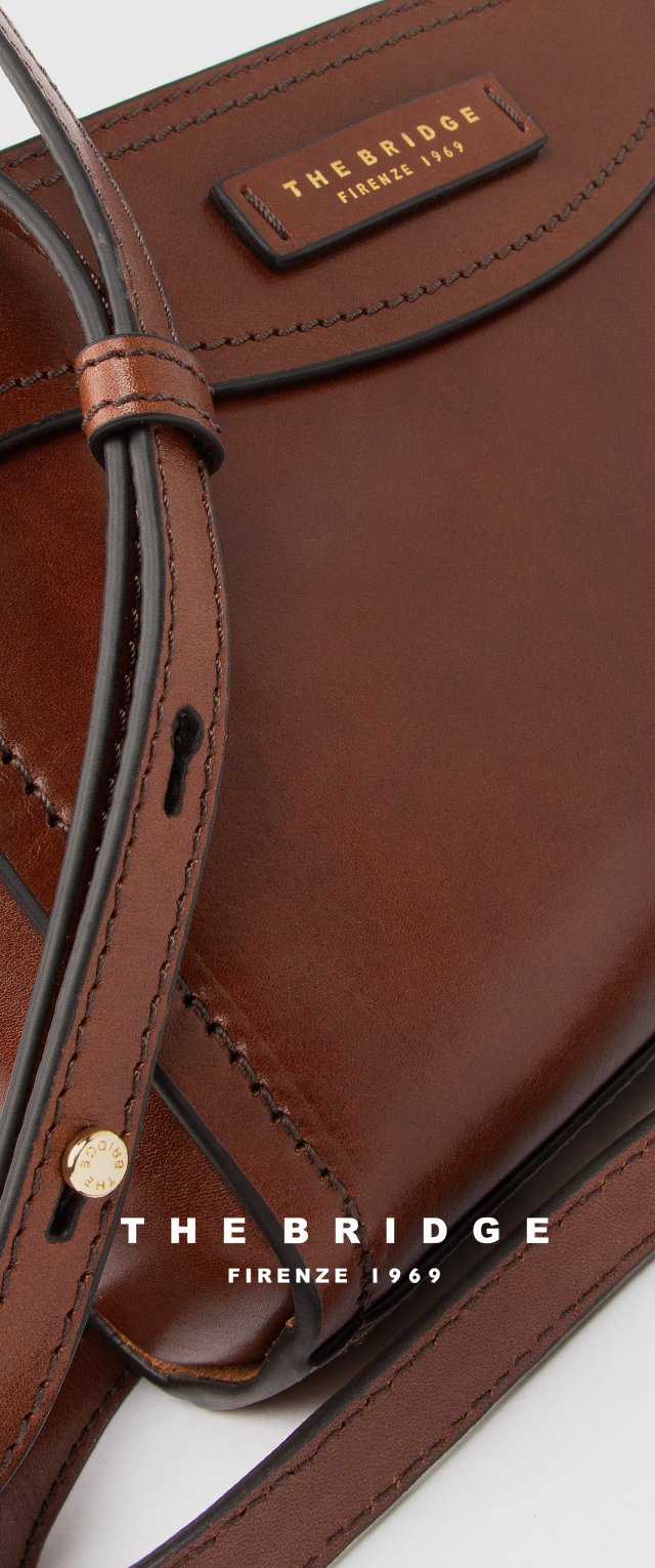 Braune Lederhandtasche mit glatter Textur, ausgestattet mit einem abnehmbaren Tragegurt und einem goldgeprägten Logo. Minimalistisches Design mit klaren Linien.