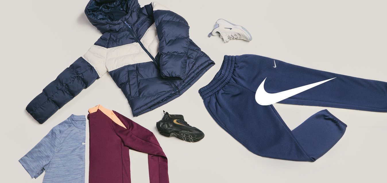 Tmavě modrá a béžová péřová bunda, modré a vínové košile, tmavě modré tepláky, černo-bílé tenisky uspořádané na světlém pozadí.