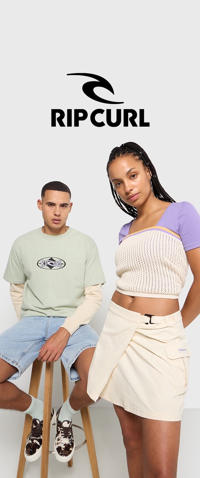 Grünes T-Shirt mit Logo, hellblaue Denim-Shorts und gemusterte Schuhe; Frau in einem gestrickten Oberteil, beiger Wickelrock mit Tasche. Neutraler Hintergrund.