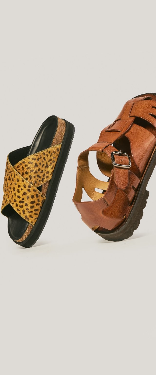 Tan leather sandal with buckle and brown leopard print slide sandal with crisscross straps on black sole.