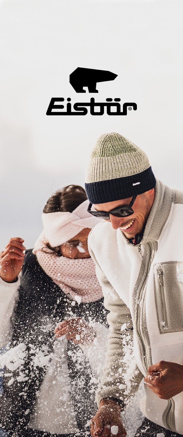 Twee mensen spelen in de sneeuw, gekleed in een grijze fleecejas, een multikleurige muts, een zonnebril, een lichtroze sjaal en een witte hoofdband.