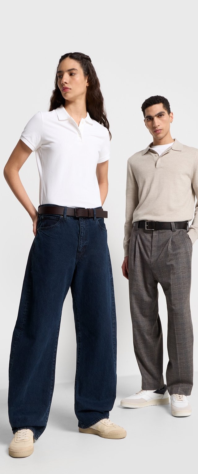 White polo shirt, dark blue wide-leg jeans, beige long-sleeve shirt, gray plaid trousers, both wearing black belts and light sneakers.