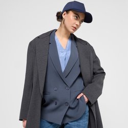 Šedý oversized blejzr přes modrou dvouřadovou vestu, doplněný modrými cargo kalhotami. Model nosí námořnickou kšiltovku, na pozadí s hladkou texturou.