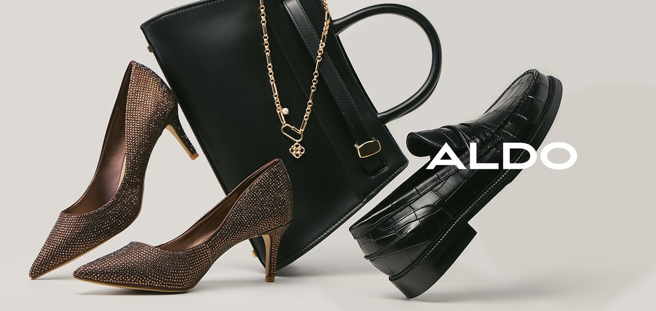 Pár hnědých vysokých podpatků, černá kožená kabelka se zlatým řetízkem a černá mokasína s krokodýlím vzorem na neutrálním pozadí.