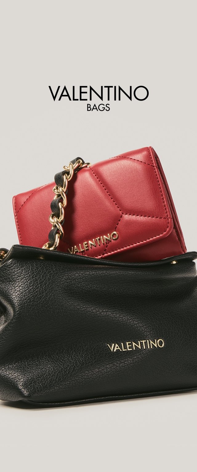 Borsa Valentino rossa trapuntata con tracolla in catena dorata appoggiata su una pochette in pelle nera testurizzata Valentino su sfondo semplice.