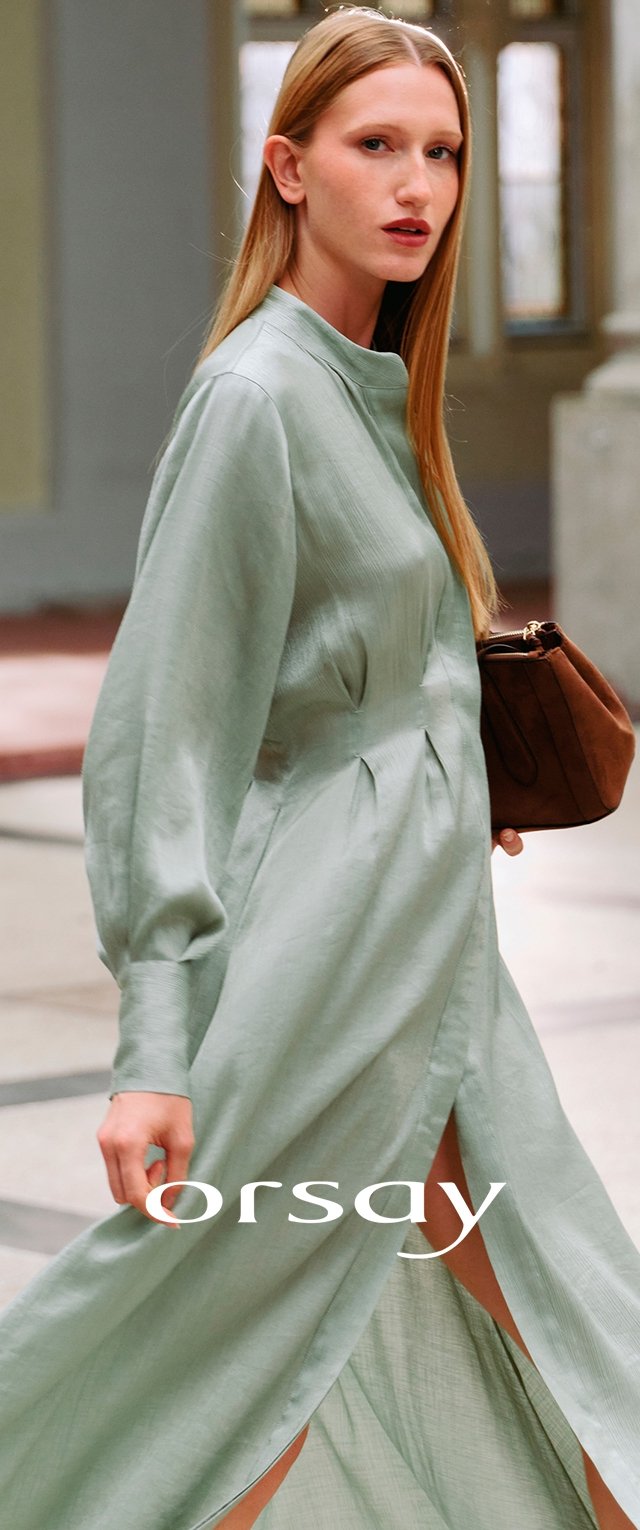 Robe à manches longues de couleur vert clair avec un col montant, des détails plissés et une fente sur le côté, accompagnée d'un sac à main marron. Texture de tissu lisse.