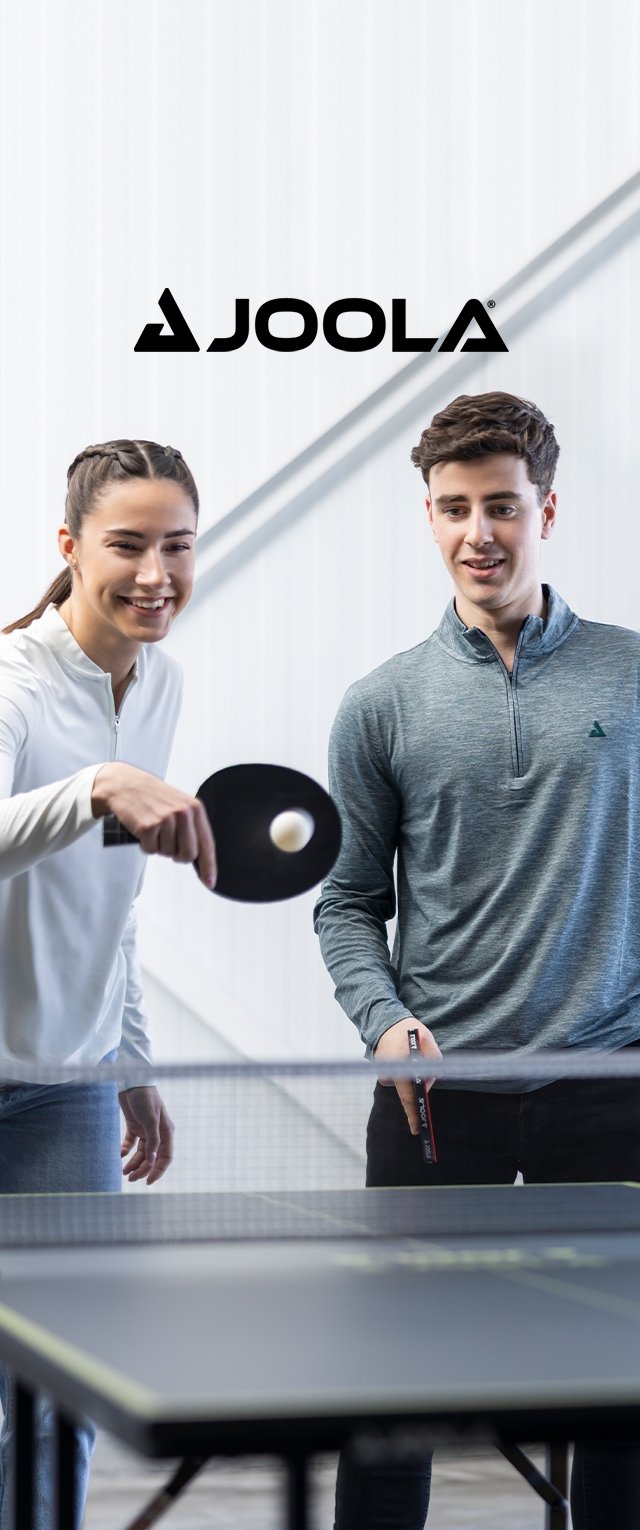 Scena di tennis da tavolo con due giocatori, una racchetta con la faccia nera, abbigliamento sportivo grigio chiaro e bianco, e una pallina da ping pong in volo.