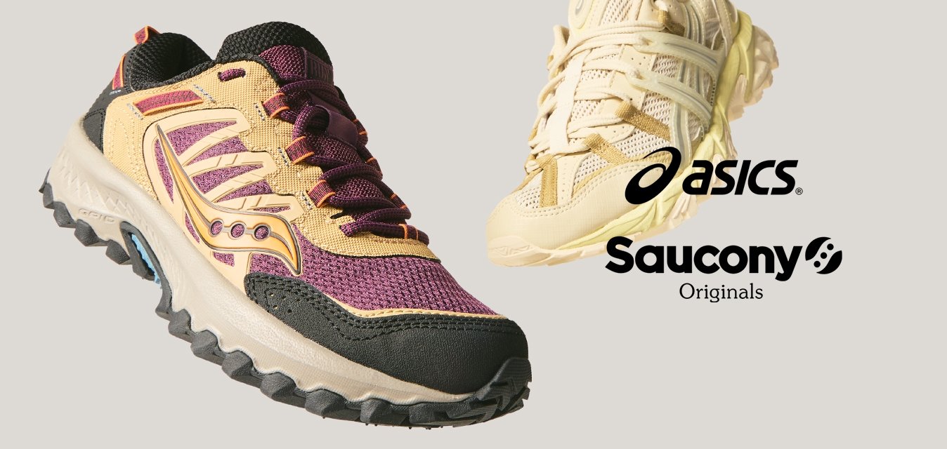 Pár sportovních bot, jedny béžové a fialové s černými akcenty, druhé světle béžové, obě s robustními podrážkami, zobrazené na jednoduchém světlém pozadí.