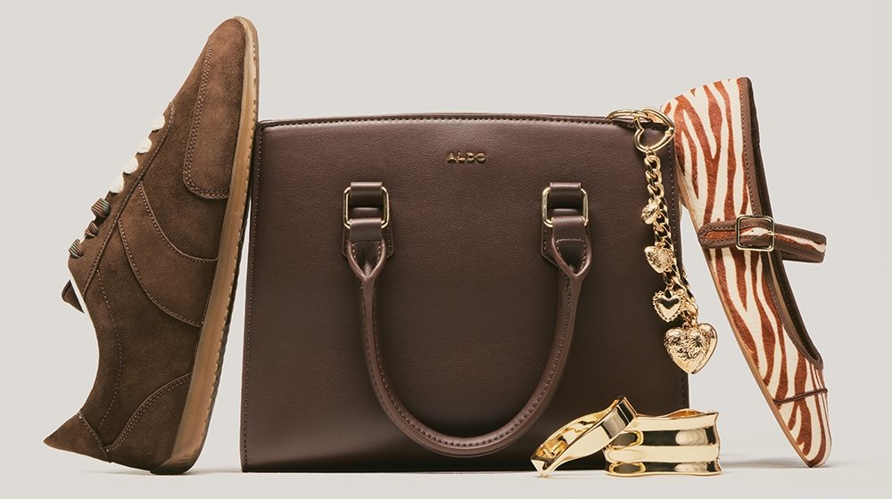Brauner Sneaker aus Wildleder, dunkelbraune Aldo-Handtasche aus Leder mit goldenem Herzanhänger, flacher Schuh im Zebra-Muster und zwei goldene Ringe.