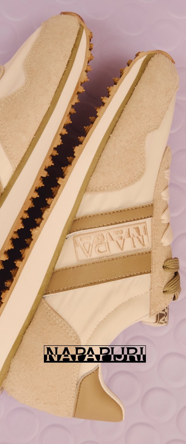 Beige en tan Napapijri sneakers met suède panelen, gestructureerde zolen en een geborduurd logodetail op een paarse golvende achtergrond.