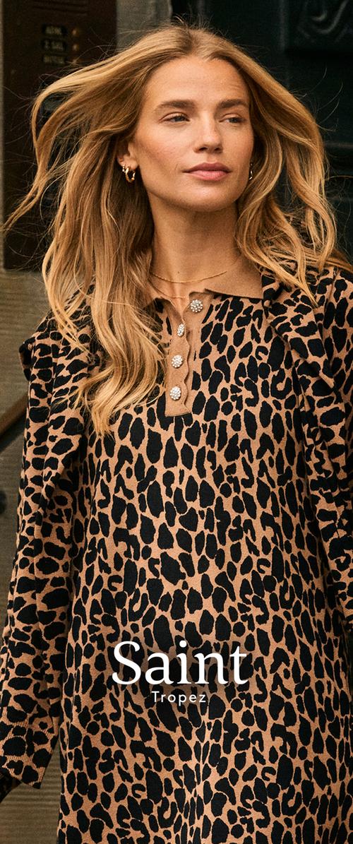 Blondínka s voľnými vlnitými vlasmi nosí dlhý rukáv s leopardím vzorom a dekoratívnymi gombíkmi, stojí vonku.