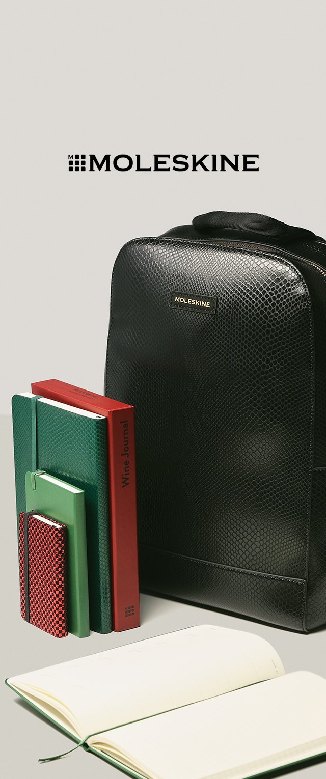 Mochila de cuero negro texturizado con un logo dorado. A su lado hay un cuaderno verde, una agenda roja, cuadernos pequeños verdes y rojos, y un planificador blanco.