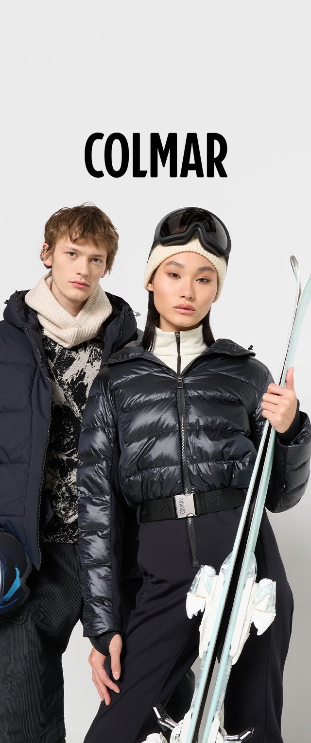 Chaqueta de plumas negra con una textura brillante y cierre de cremallera, llevada sobre una camiseta blanca; el modelo masculino lleva una bufanda de punto y un suéter de estampado.