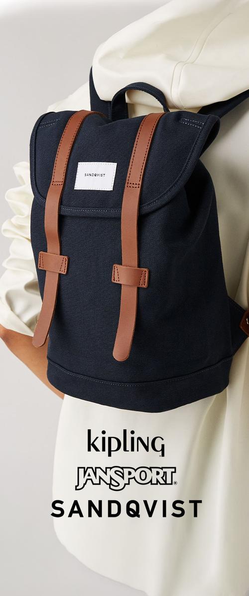 Sac à dos bleu marine avec des sangles en cuir marron porté par une personne portant un vêtement de couleur claire, avec le logo Sandqvist sur le rabat avant.