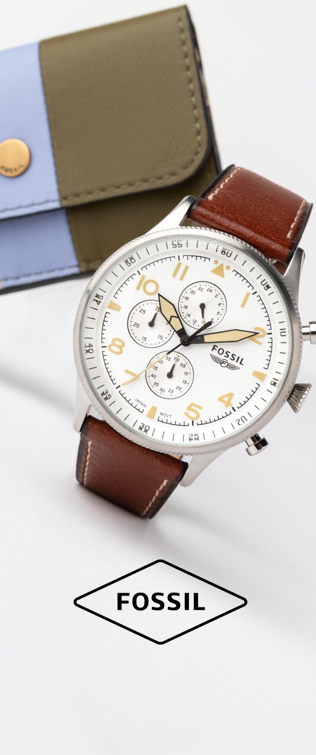 Reloj Fossil con caja plateada, esfera blanca, correa de cuero marrón y funciones de cronógrafo. Acompañado de una cartera verde y azul.