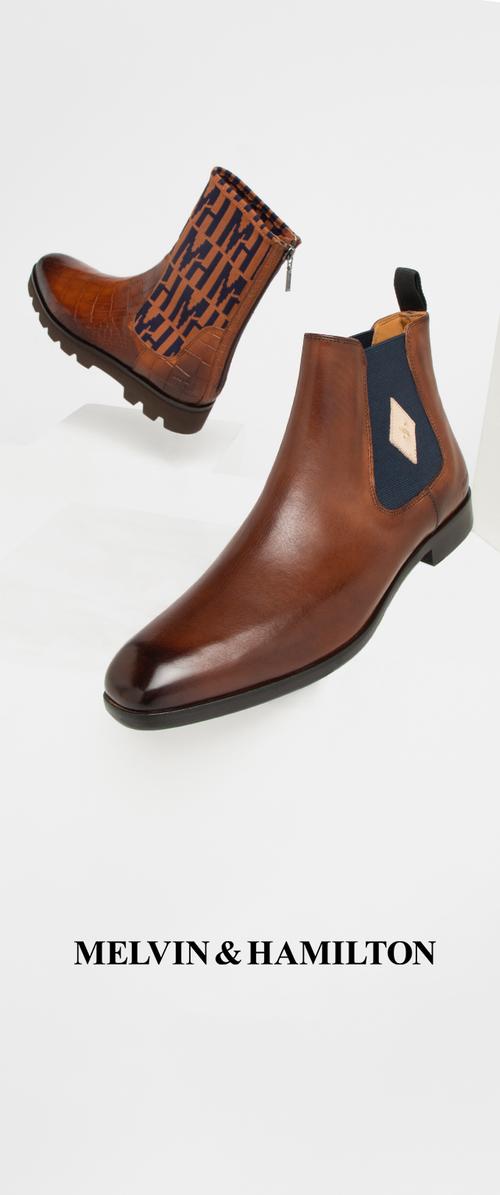 Brown leather ankle boots with a smooth finish, featuring a patterned textile shaft and elastic side panels, displayed against a white background.